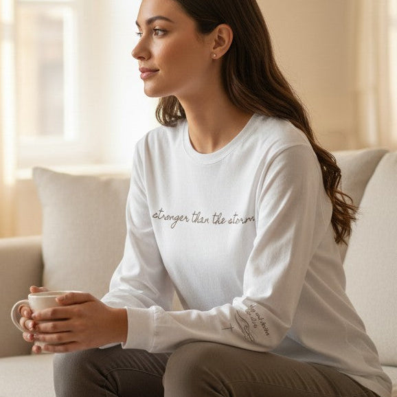 Woman sitting on a couch holding a mug in a cozy living room.