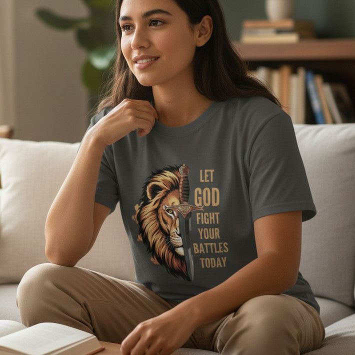 Woman sitting on a couch in a living room wearing a t-shirt with a graphic and text.