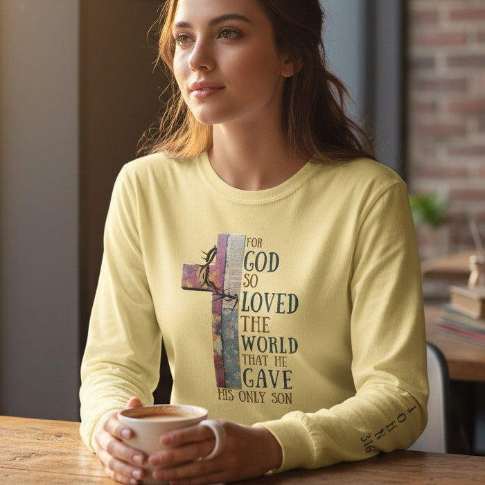 Woman in a yellow long-sleeve shirt sitting at a table in a cafe holding a cup.