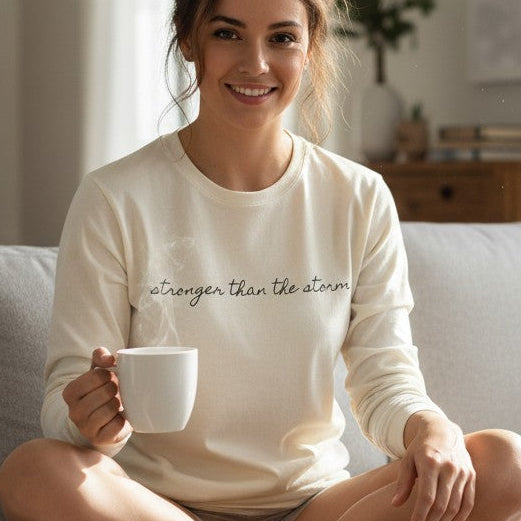 Woman sitting on a couch holding a mug in a cozy living room.