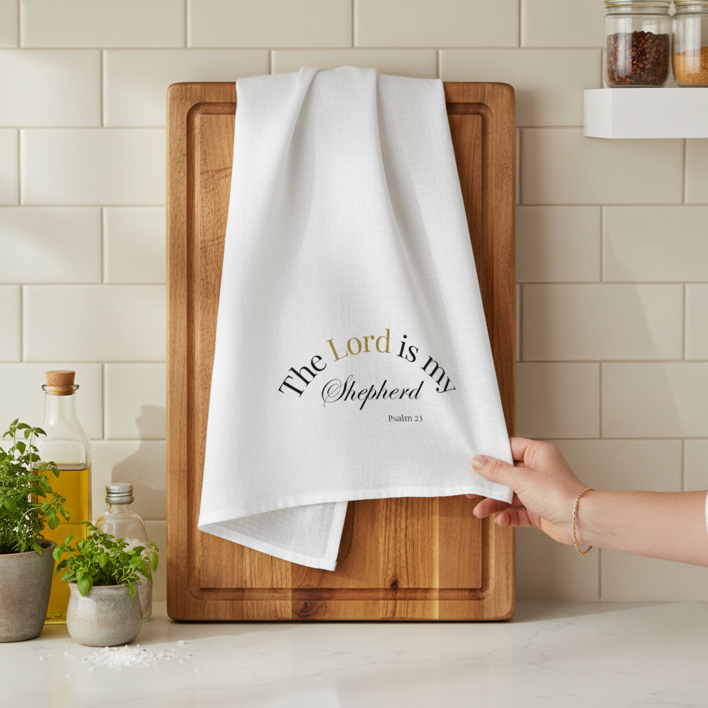 White towel with 'The Lord is my Shepherd' text on a wooden cutting board in a kitchen.