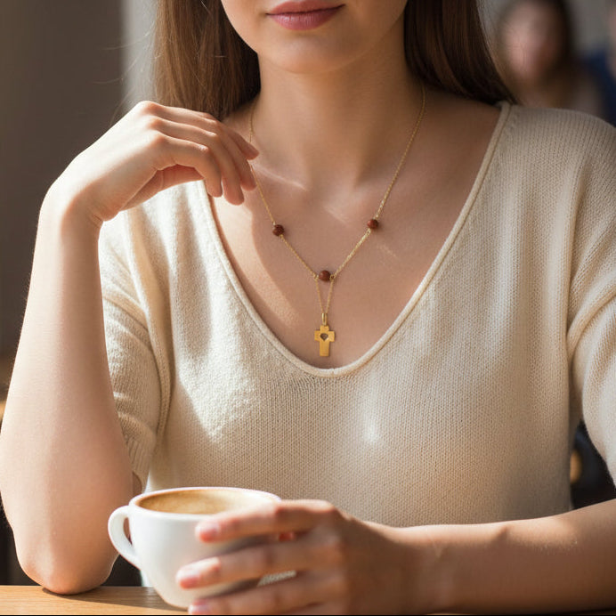 Woman sitting at a table holding a cup of coffee in a casual setting.