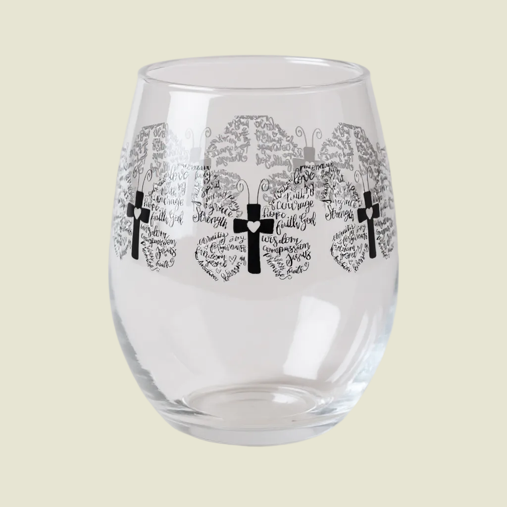Clear glass tumbler with black cross and text design on a white background