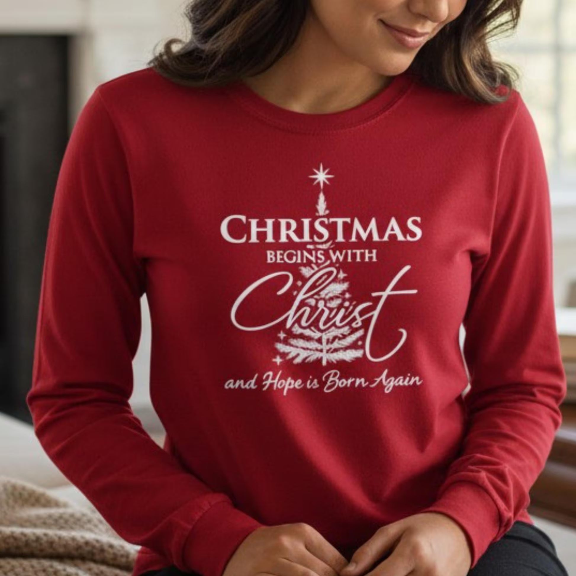 Red sweatshirt with Christmas-themed text worn by a person indoors.