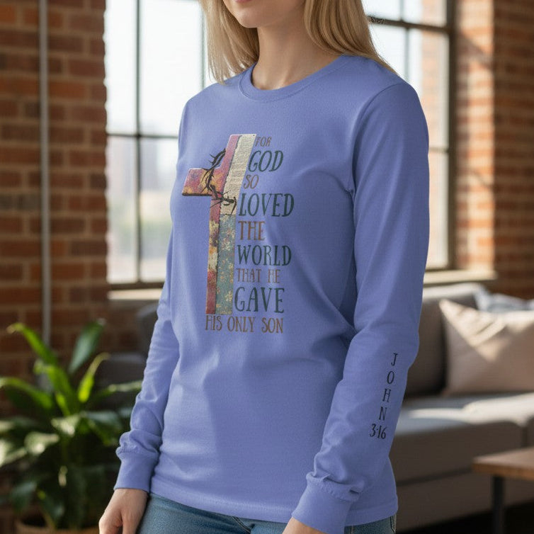 Woman wearing a blue long-sleeve shirt with a graphic design in a room with a couch and plant.