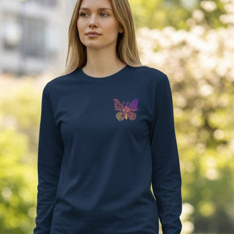 Woman wearing a navy blue long-sleeve shirt with a butterfly design in a park.