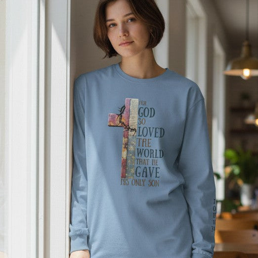 Person wearing a light blue sweatshirt with a cross design in a casual setting.